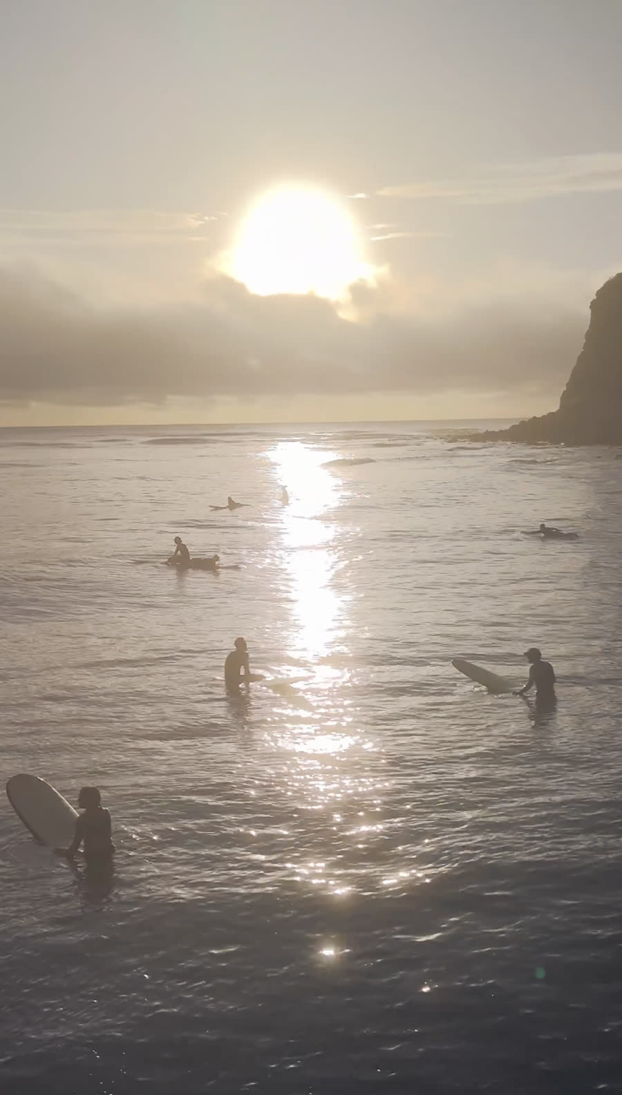 Groupe de surfeurs au coucher de soleil