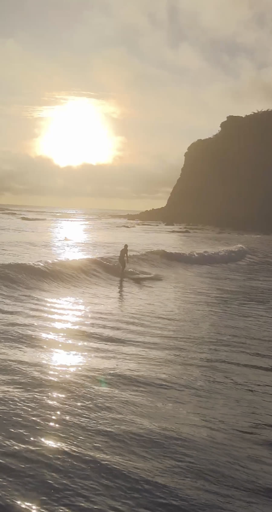 Silhouette de surfeur au coucher de soleil